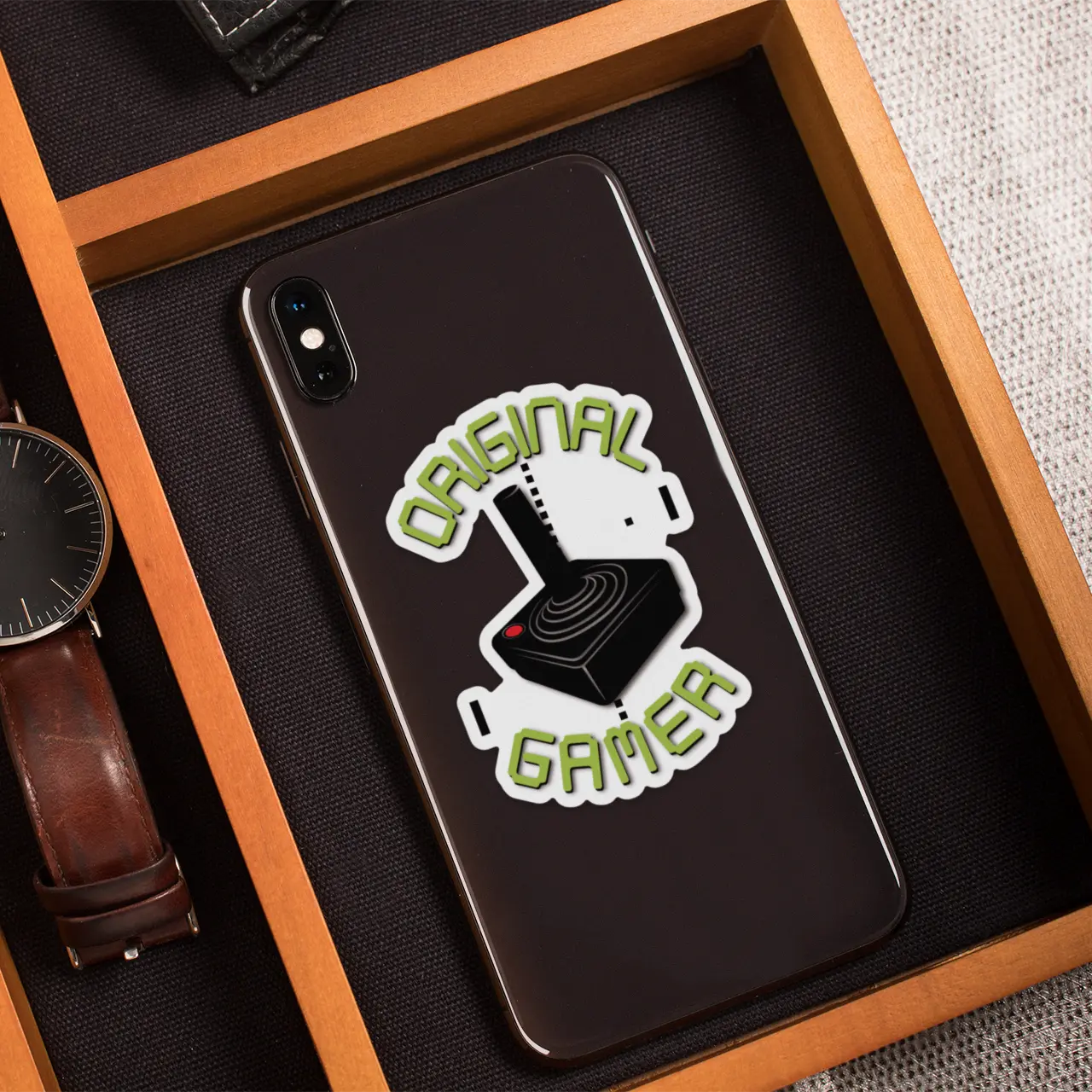 Original Gamer 3" Die-Cut Vinyl Sticker on an Android phone in an elegant wooden box