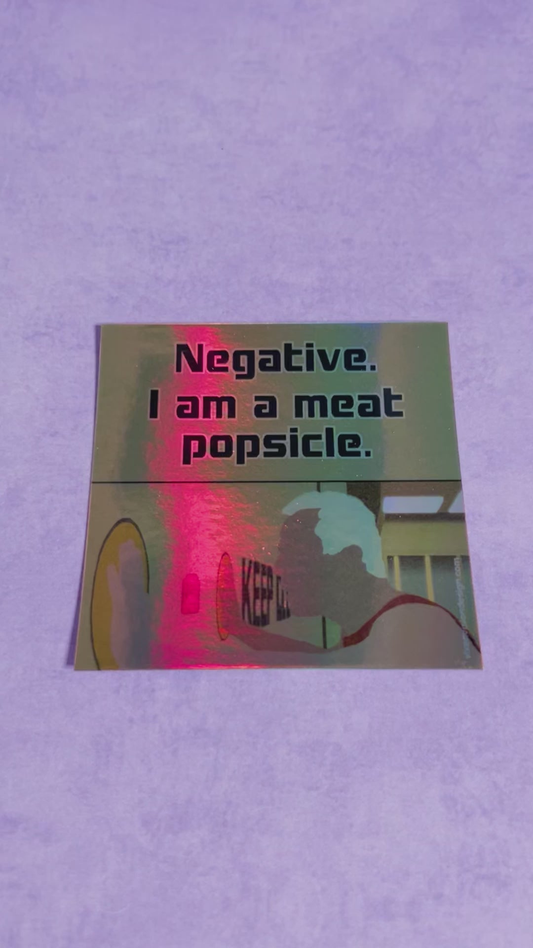Meat Popsicle Holographic 3" Vinyl Sticker tilted back on a purple background