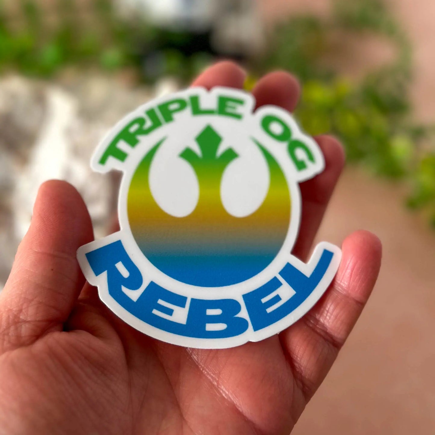 Triple OG Rebel 3" Vinyl Sticker in a hand