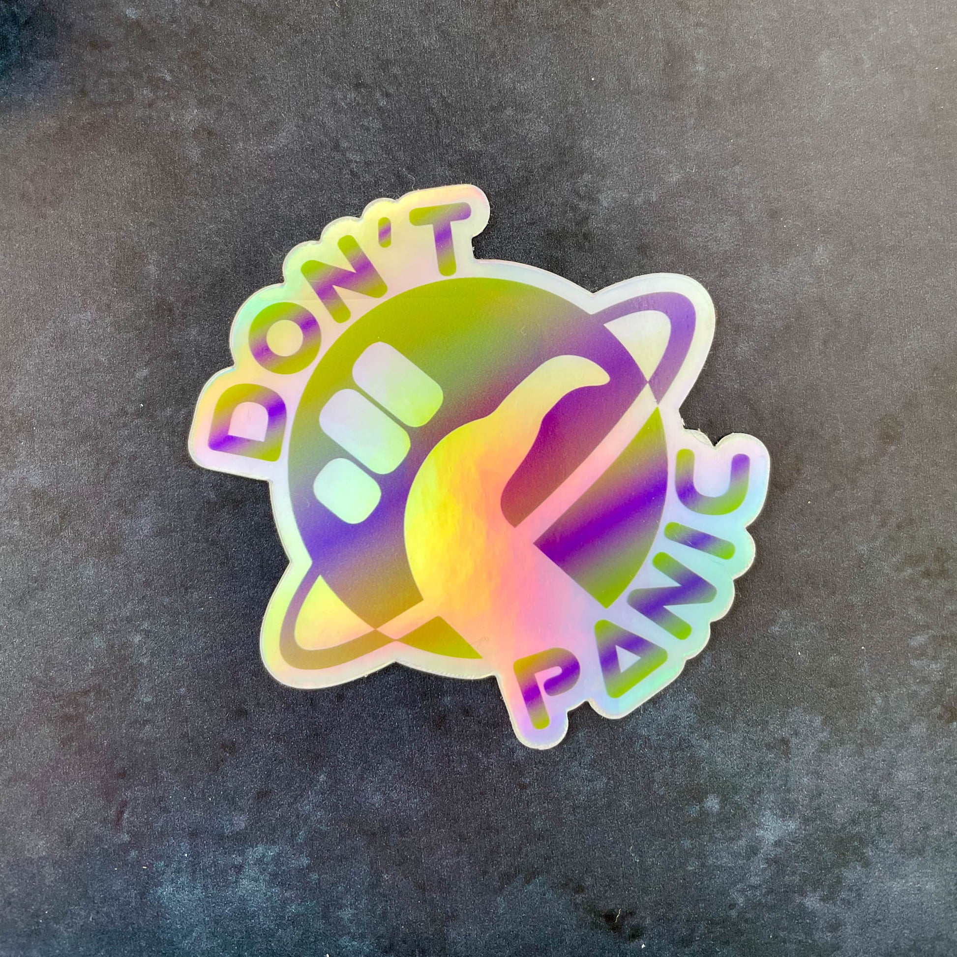Don't Panic Holographic 3" Sticker on dark blue background close up