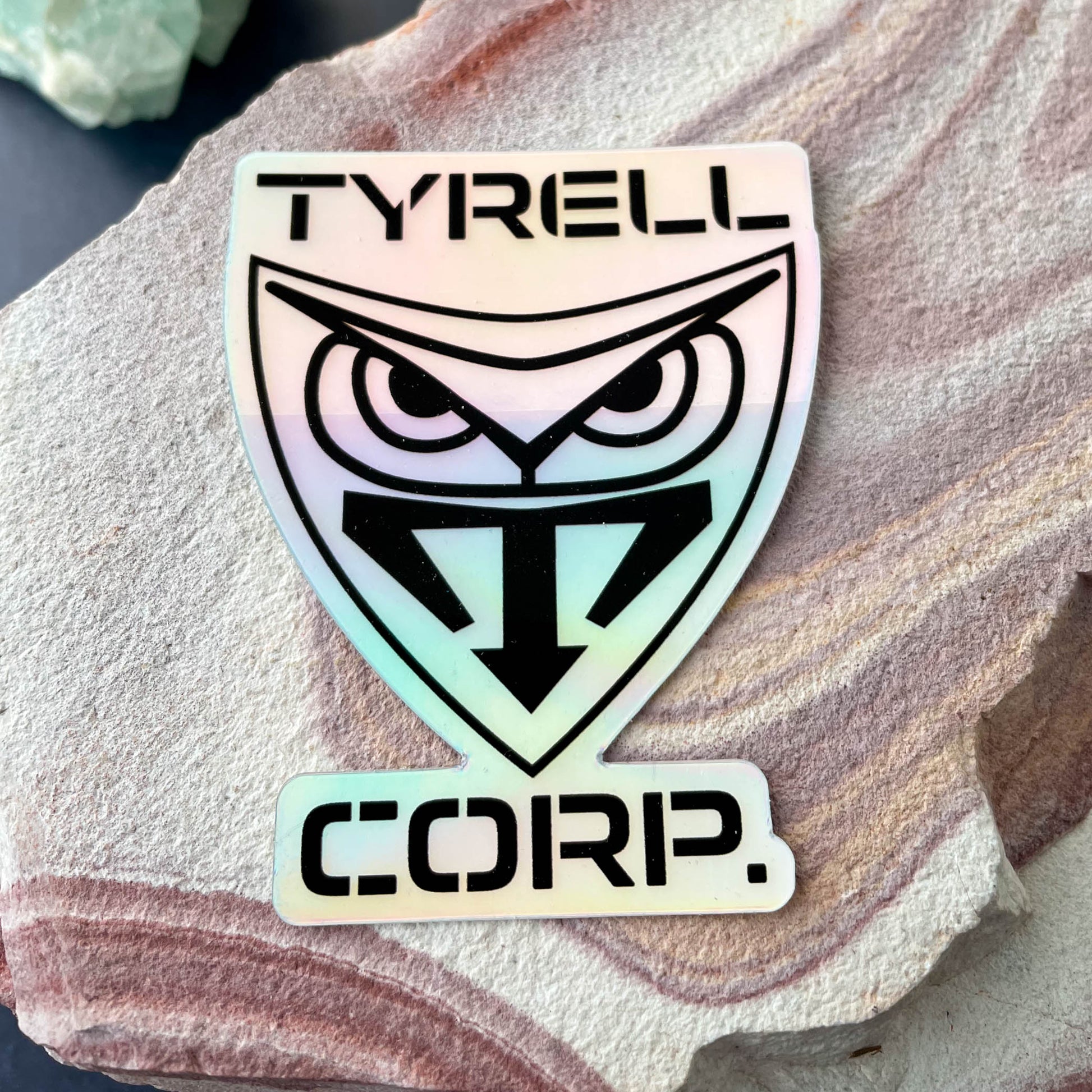 Tyrell Corp Holographic 3" Sticker on rock