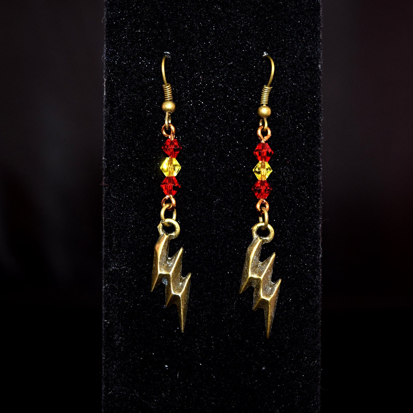 Antique Bronze and Glass Bead Lightning Bolt Earrings against black background
