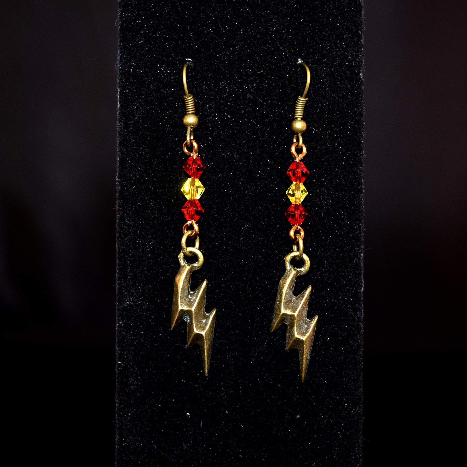 Antique Bronze and Glass Bead Lightning Bolt Earrings against black background