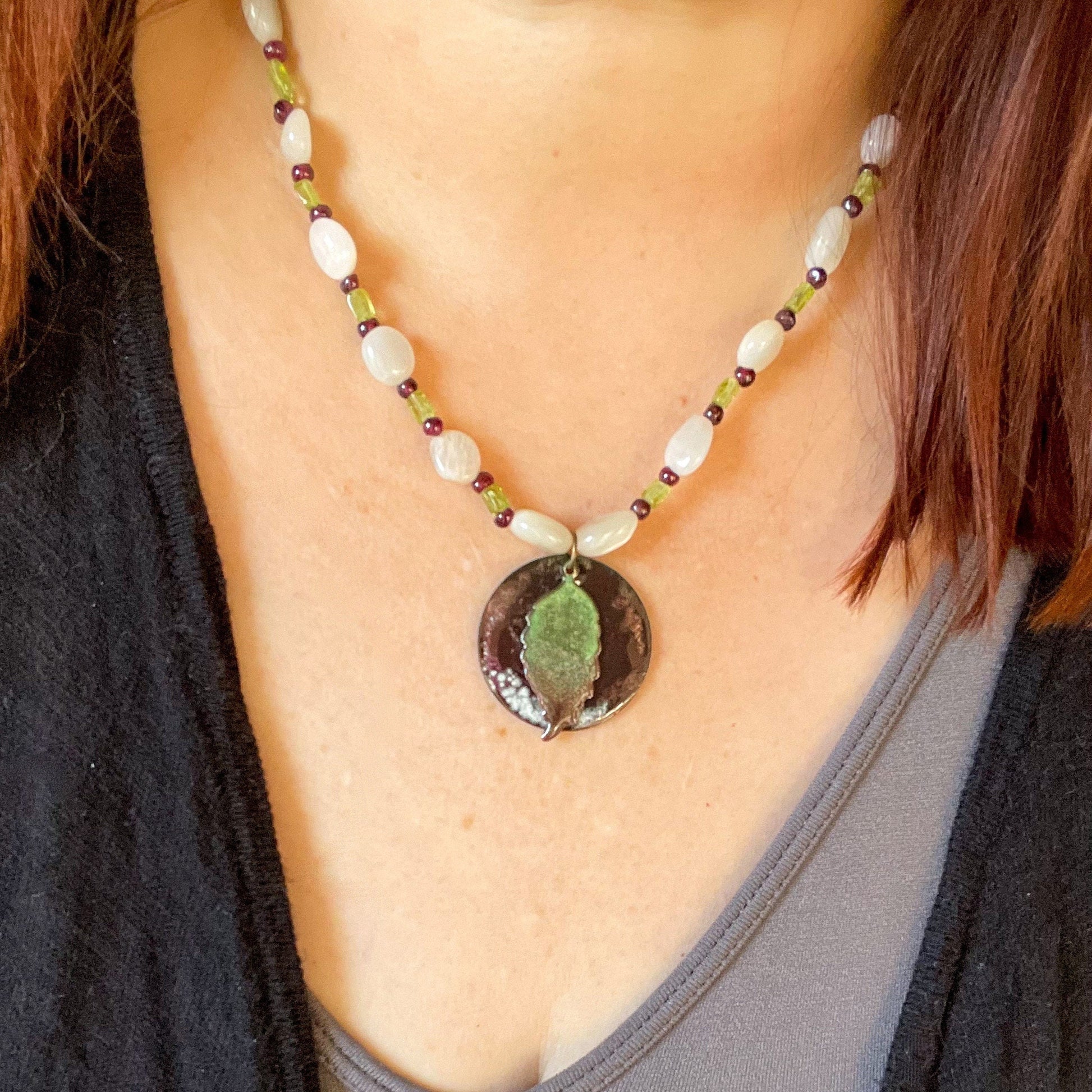 Green Leaf and Burgundy Circle Layered Enamel Pendant Moonstone, Garnet, and Peridot Bead Necklace on model