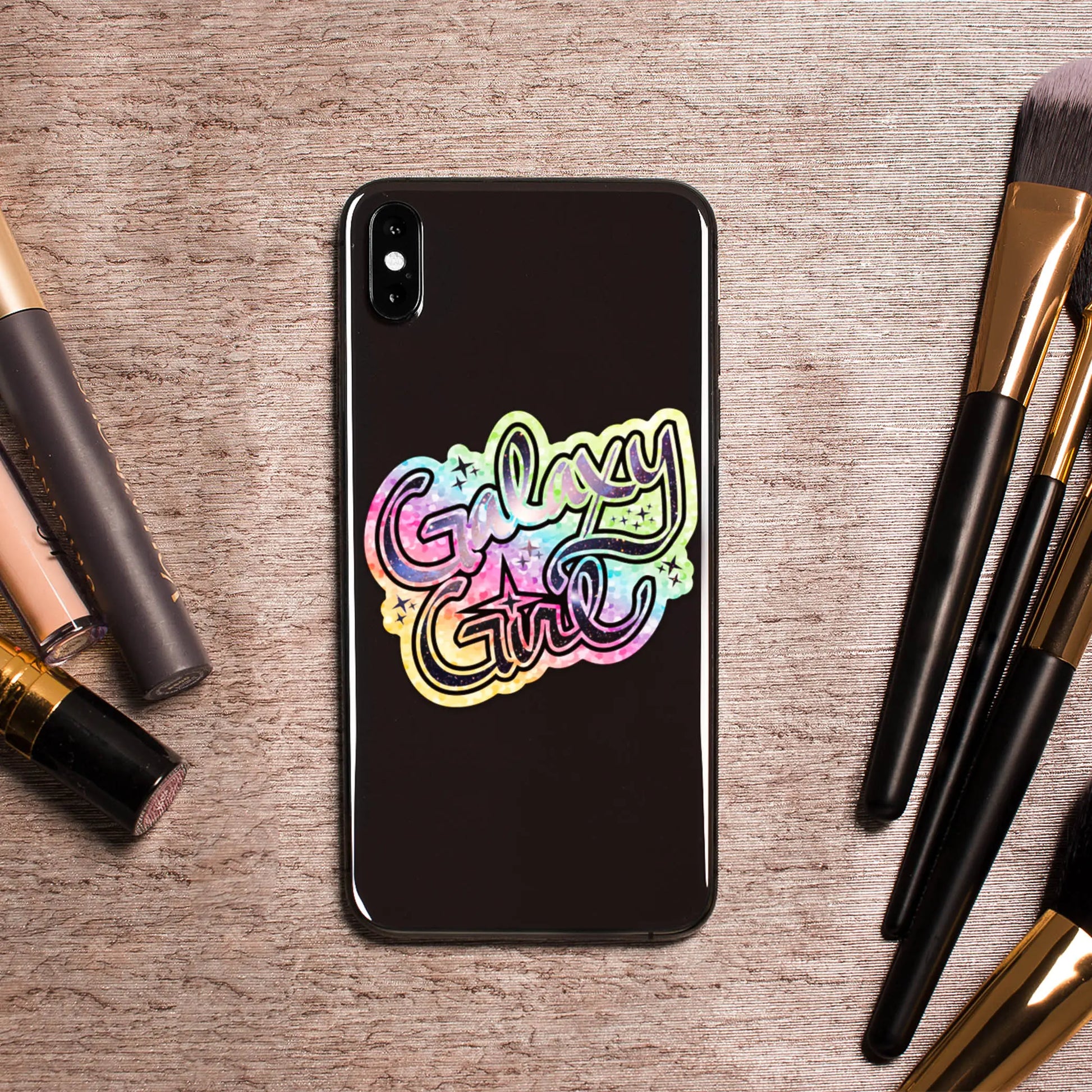 Galaxy Girl Die-Cut Sparkle 3" Vinyl Sticker on phone surrounded by cosmetics