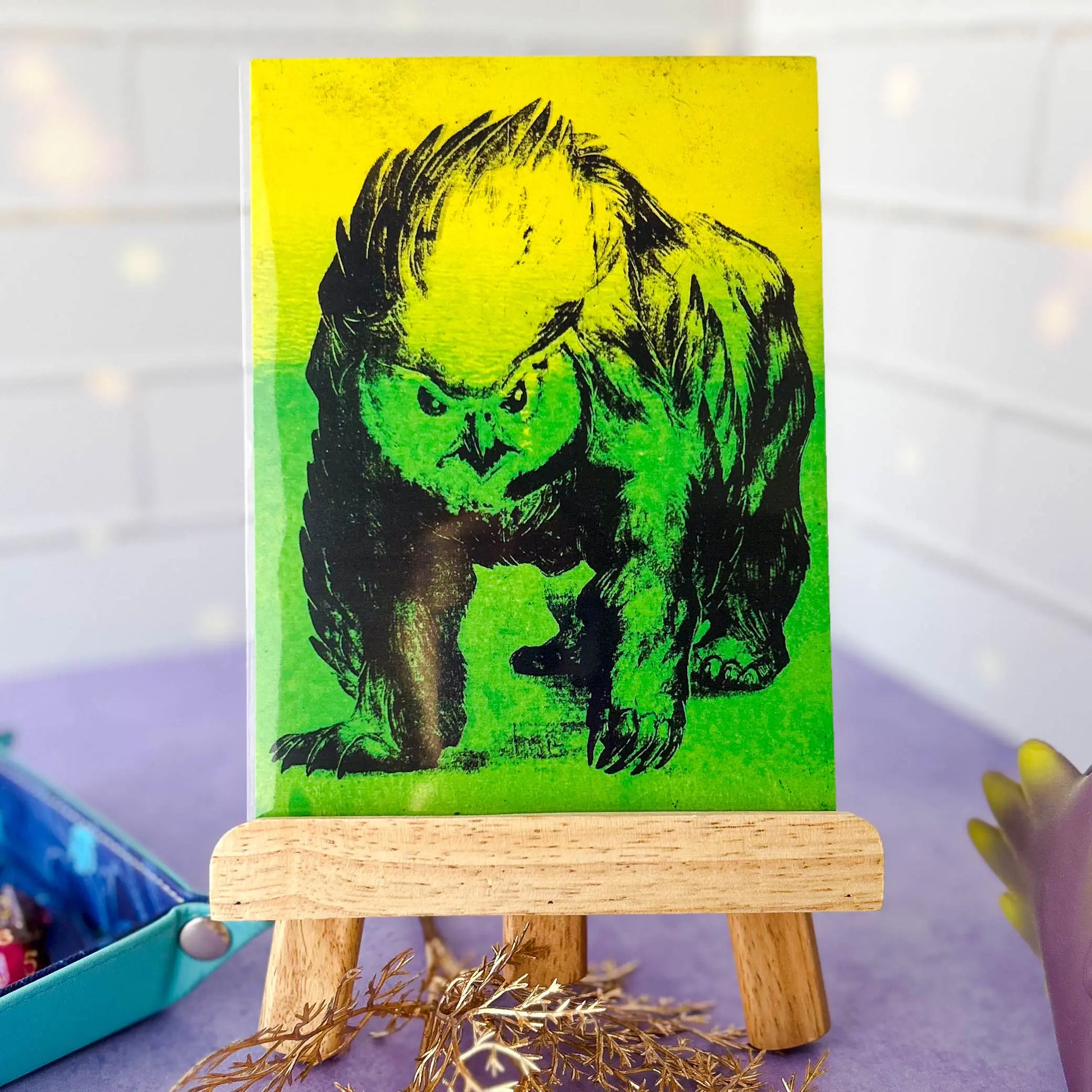 Glowing Feathered Fury 5x7 Art Card on an easel in a protective sleeve