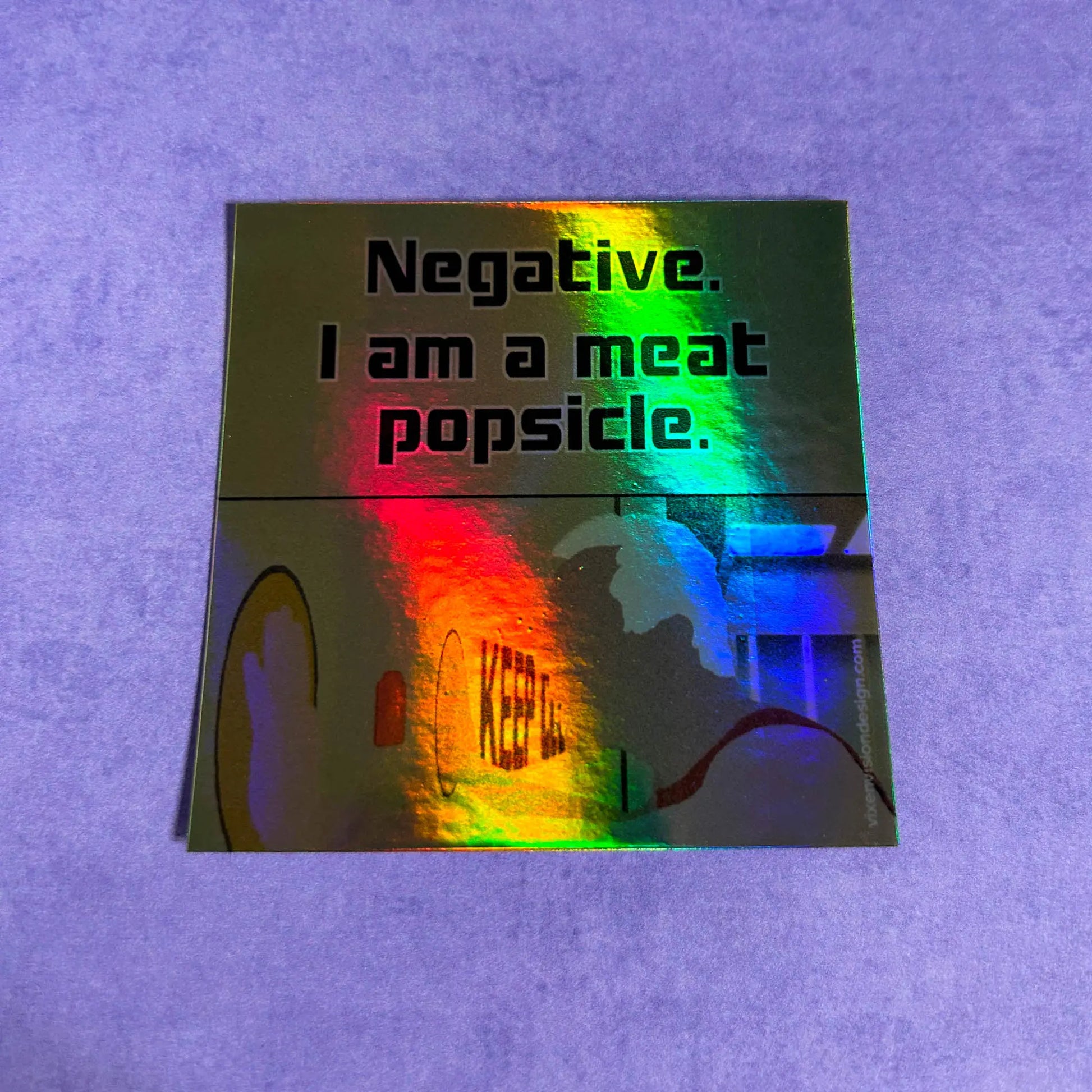 Meat Popsicle Holographic 3" Vinyl Sticker slightly tilted back on a purple background