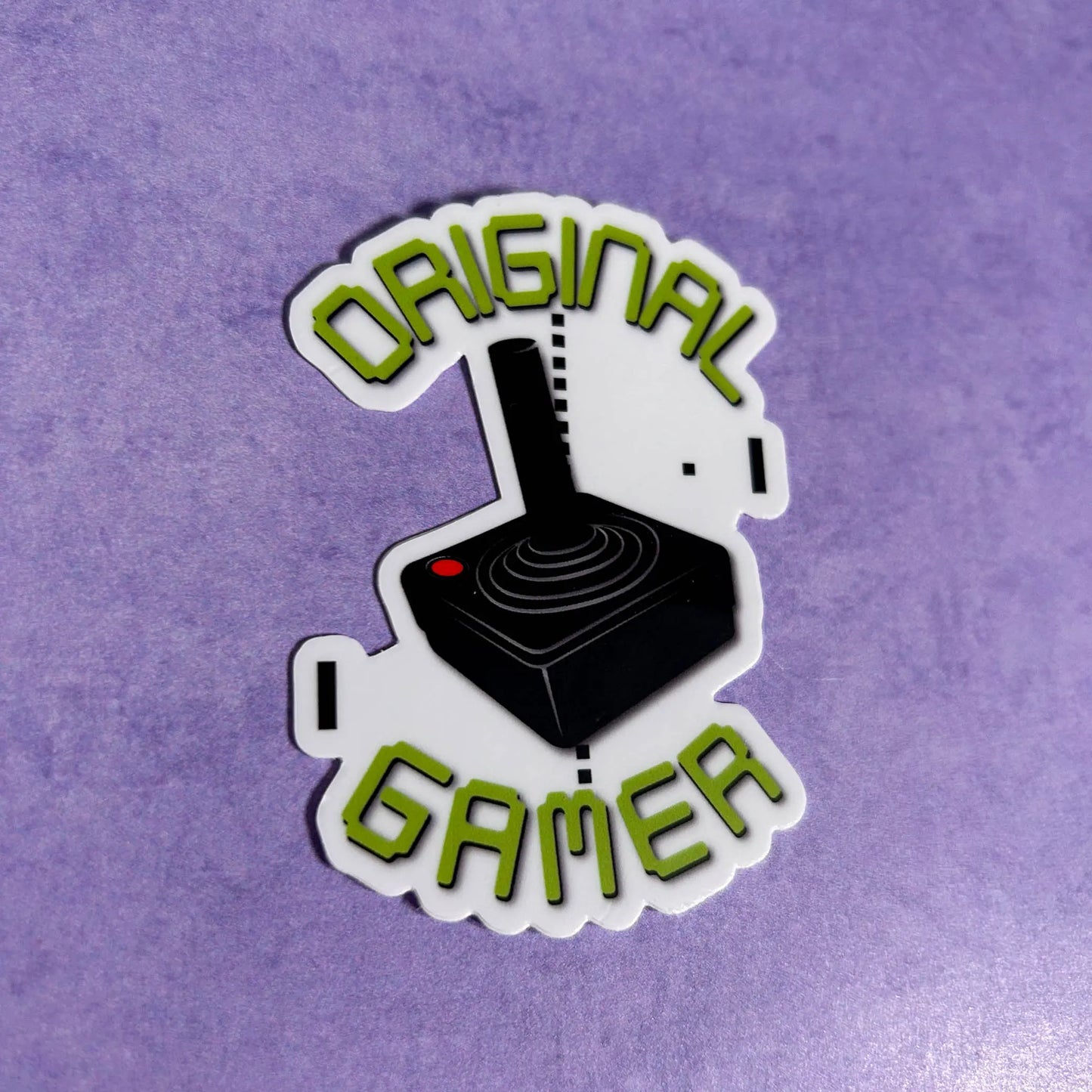 Original Gamer 3" Die-Cut Vinyl Sticker tilted to the right on a purple background