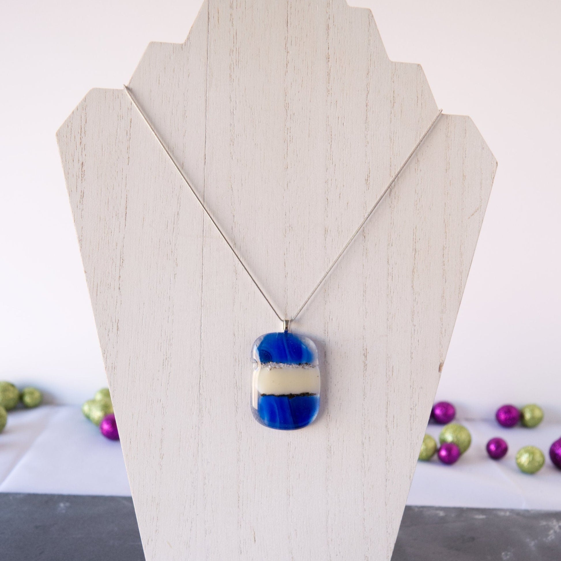 Cobalt Blue and Cream Abstract Fused Glass Pendant Necklace on white wood