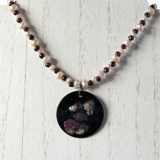 Copper Enamel Pendant and Garnet and Glass Bead Necklace on white wood